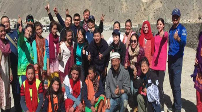 Tourists from China watch a polo match in Hunza