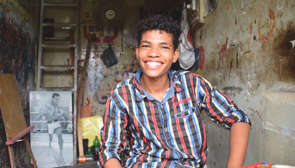 Muhammad Jawad Ahmed Jan smiles at the camera as I caught him during work at his shop in Lyari, Karachi, Pakistan. June 18, 2017. Image by author.