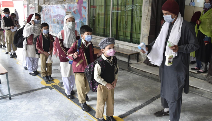 Student wear face masks as they arrive at their school at Peshawars Gulbhar colony, on February 1, 2021. &mdash; INP/File