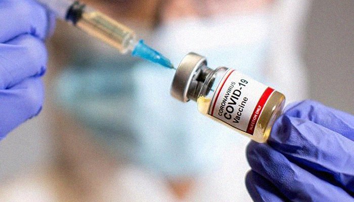 A woman holds a small bottle &mdash; labeled Coronavirus COVID-19 Vaccine &mdash; and a medical syringe, October 30, 2020. Photo: Reuters