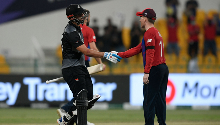 New Zealands Daryl Mitchell shakes hands with Englands captain Eoin Morgan (R) after New Zealands victory at the end of the ICC Twenty20 World Cup semi-final match between England and New Zealand at the Sheikh Zayed Cricket Stadium in Abu Dhabi on November 10, 2021. — AFP