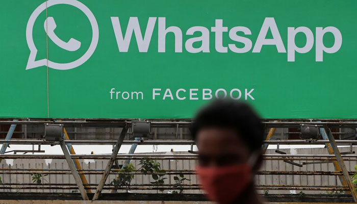 A man walks past a hoarding of the WhatsApp application installed at a skywalk in Mumbai, India, August 26, 2021. &mdash; Reuters/File