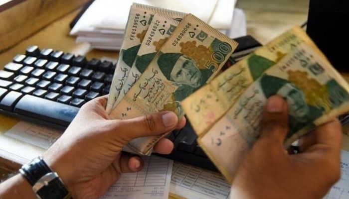 A man counting Pakistani rupees. Photo&nbsp;&mdash; AFP/File