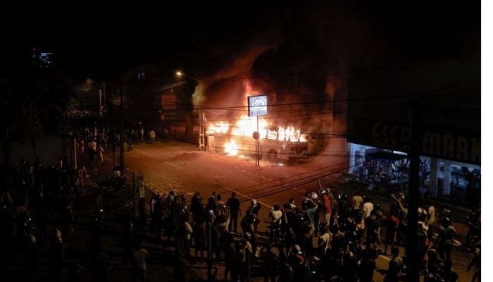 Demonstrators stand near a bus that was set on fire at the top of the road to Sri Lankan President Gotabaya Rajapaksas residence during a protest against him as many parts of the crisis-hit country faced up to 13 hours without electricity due to a shortage of foreign currency to import fuel, in Colombo, Sri Lanka March 31, 2022. —Reuters