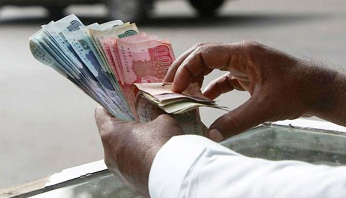 A man counts rupee notes in a bundle. &mdash; Reuters
