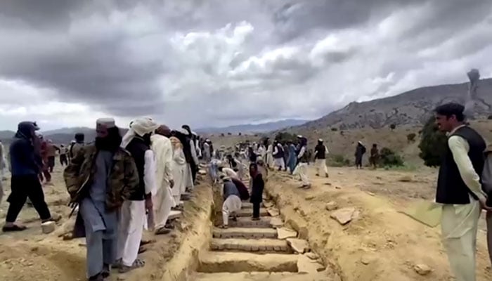 Screengrab of video showing people digging graves to bury the dead after earthquake. &mdash;Reuters