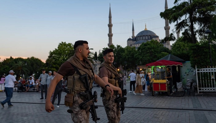 Turkish riot police officers walk in front of the Blue Mosque in Istanbul. &mdash; AFP