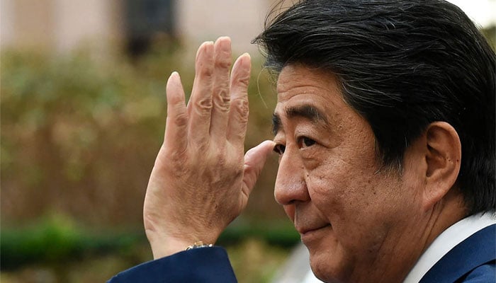 Former Japanese premier Shinzo Abe waves at people. &mdash; AFP/File