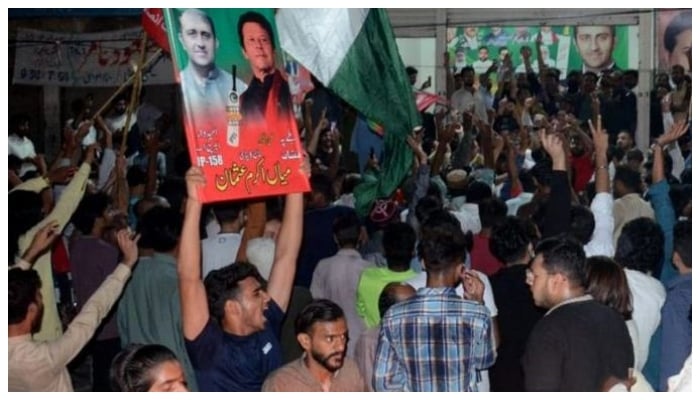 PTI workers dance with jubiliation as they win a crucial election in PP 158 Lahore. &mdash; APP