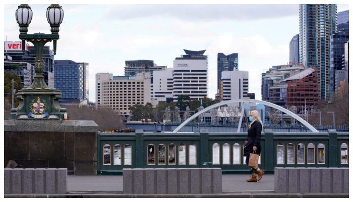 A lone woman, wearing a protective face mask, walks across a city centre bridge as the state of Victoria looks to curb the spread of a COVID-19 outbreak in Melbourne, Australia, July 16, 2021. &mdash; Reuters
