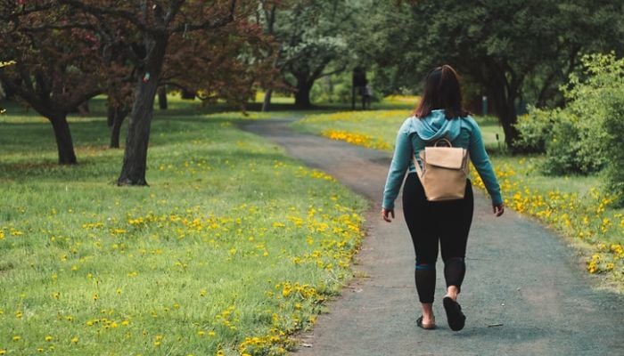 Woman walking in a park. &mdash; Unsplash