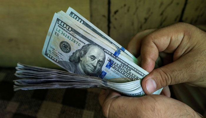 A currency dealer counting the US dollar. &mdash; Reuters/File