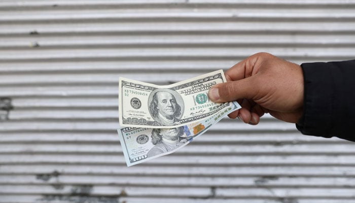 A street-side currency vendor holds US dollars at Ferdowsi Square in Tehran, Iran November 14, 2021.&nbsp;&mdash; Reuters/File