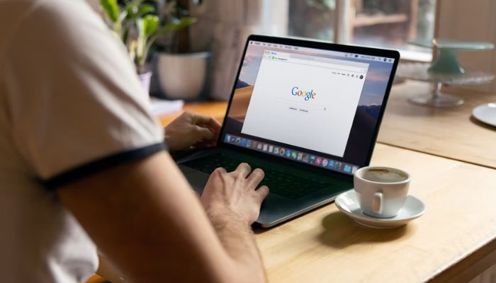 Man uses Apple MacBook in a cafe, searching Google website.&nbsp;&mdash; Unsplash