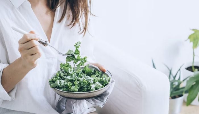 Woman eating Kale salad.&mdash; Unsplash