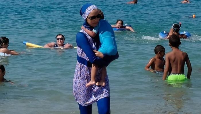 A woman wearing a burkini walks in the water August 27, 2016 on a beach in Marseille, France, the day after the countrys highest administrative court suspended a ban on full-body burkini swimsuits that has outraged Muslims and opened divisions within the government, pending a definitive ruling. &mdash;&nbsp; Reuters