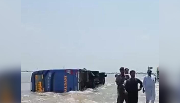 Image shows bus turning turtle in Dadu, Sindh amid flash flooding, on August 30, 2022. &mdash; Photo by author