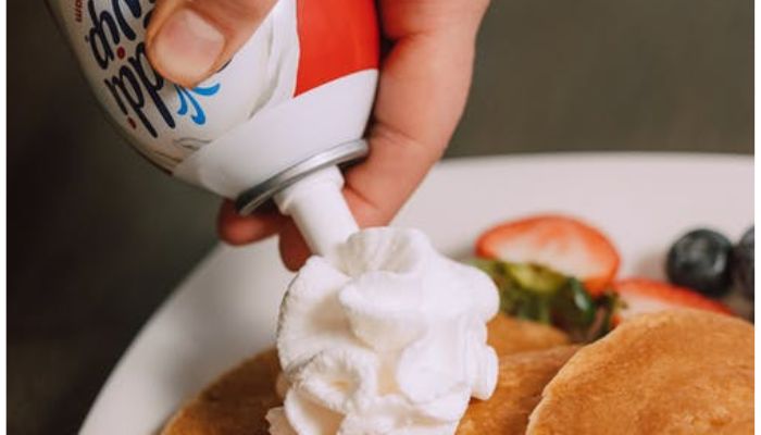 A Person Putting Whipped Cream on the Pancakes.&mdash; Pexel