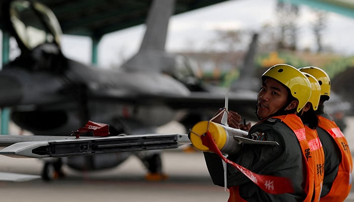 Air force crews lift an AIM-9 Sidewinder air-to-air missiles to be loaded onto Northrop F-5 fighter during a military drill at Zhi-Hang Air Base in Taitung, Taiwan January 30, 2018. &mdash; Reuters