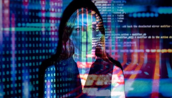 Female software engineer with projected code. —Unsplash