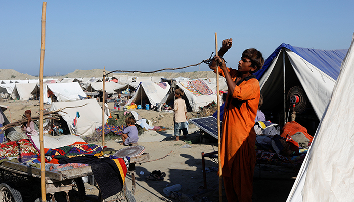 Wakeel, 15, displaced because of the floods, prepares a makeshift shelter as his family takes refuge in a camp, in Sehwan, Pakistan, on September 30, 2022. — Reuters