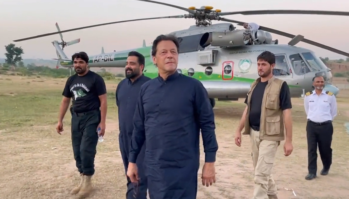 PTI chief and former prime minister Imran Khan walks towards Bani Gala after his helicopter made an emergency landing near Adiala jail on October 8, 2022. — Twitter