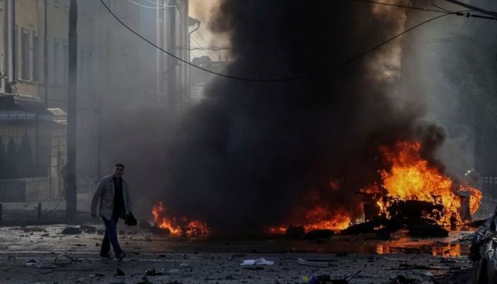 A driver walks near his burned car after Russian military strike, as Russias invasion of Ukraine continues, in central Kyiv, Ukraine October 10, 2022. — Reuters