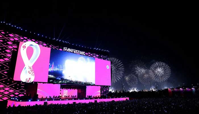 General view of fans at a stage during the opening of the FIFA fan festival as fireworks explode in the background. — Reuters