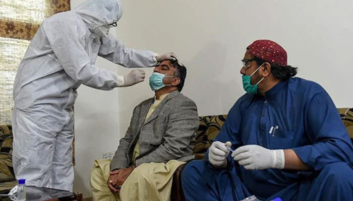 A health worker takes a testing sample from a journalist during a nationwide lockdown over the Covid-19 pandemic in Pakistan. — AFP