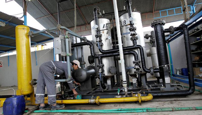 A worker drains water from a gas filter at the Egas processing plant in Gujar Khan, Pakistan March 10, 2017. — Reuters/File