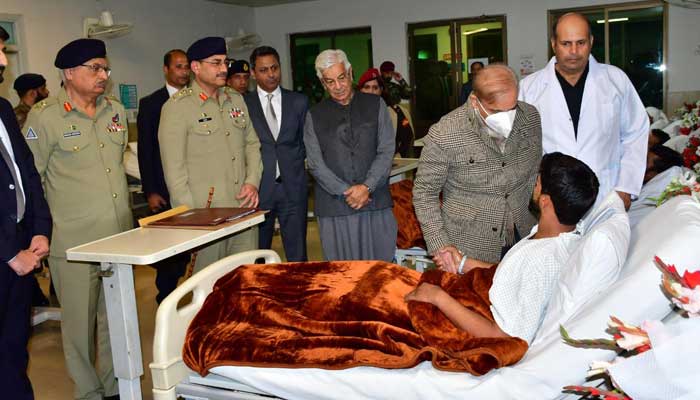 Prime Minister Shehbaz Sharif, flanked by Defence Minister Khawaja Asif and Chief of Army Staff (COAS) General Asim Munir, visits injured soldiers, who took down terrorists in Bannu operation, on December 22, 2022. — APP