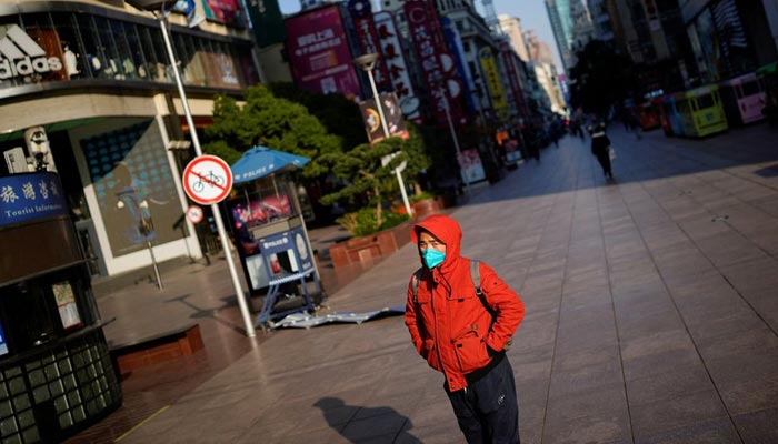 A man wearing a mask walks along an empty shopping area, as coronavirus disease (COVID-19) outbreaks continue in Shanghai, China, December 22, 2022. — Reuters