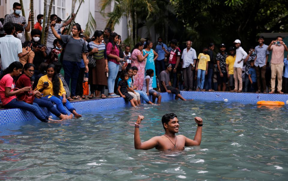 A man stands in the swimming pool as people visit the Presidents house on the day after demonstrators entered the building, after President Gotabaya Rajapaksa fled, amid the countrys economic crisis, in Colombo, Sri Lanka July 10, 2022. — Reuters