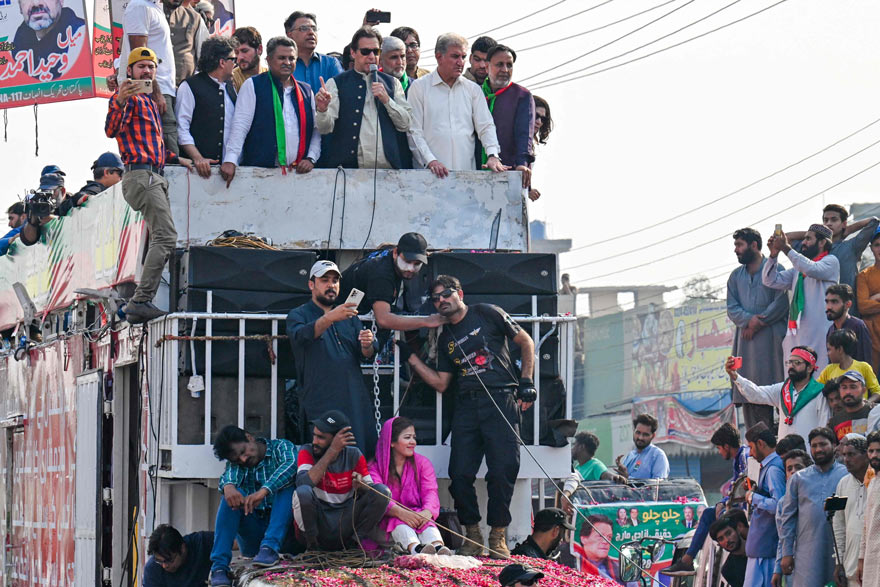 Former Pakistan prime minister Imran Khan (C) addresses his supporters during an anti-government long march towards Islamabad to demand early elections, in Lahore on October 29, 2022. — AFP