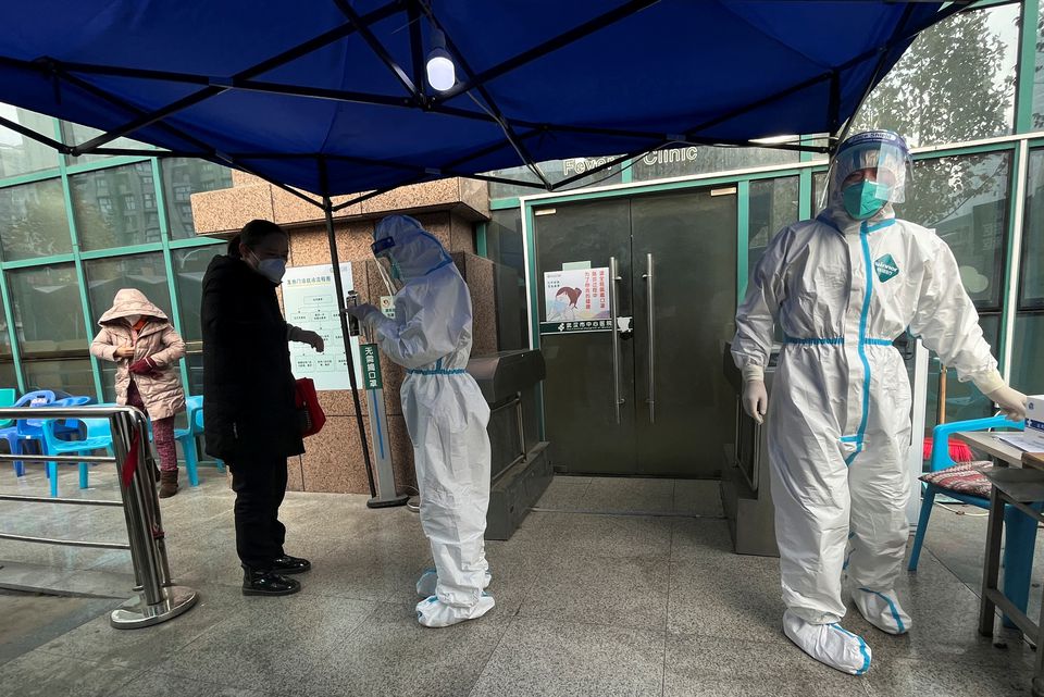 A medical worker in a protective suit checks a thermometer for a patient at the entrance to the fever clinic of the Central Hospital of Wuhan, amid of the coronavirus disease (COVID-19) outbreak, in Wuhan, Hubei province, China December 31, 2022.— Reuters