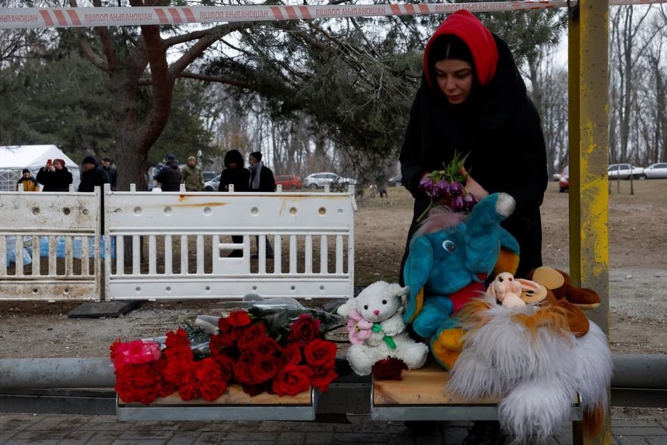 A woman leaves tributes near the site where an apartment block was heavily damaged by a Russian missile strike, amid Russias attack on Ukraine, in Dnipro, Ukraine January 16, 2023.— Reuters
