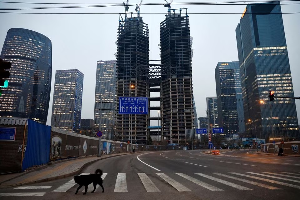 A dog crosses a road at a financial district with buildings under construction, in Beijing, China January 11, 2023.— Reuters