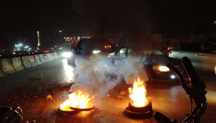 Political workers burn tyres while protesting at Karachis University Road on January 18, 2023. — Geo.tv