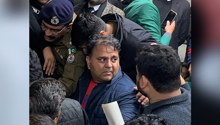 Police officials escort the arrested leader of opposition Pakistan Tehreek-e-Insaf (PTI) party, Fawad Chaudhry (C) to present him before a court in Lahore on January 25, 2023. — AFP