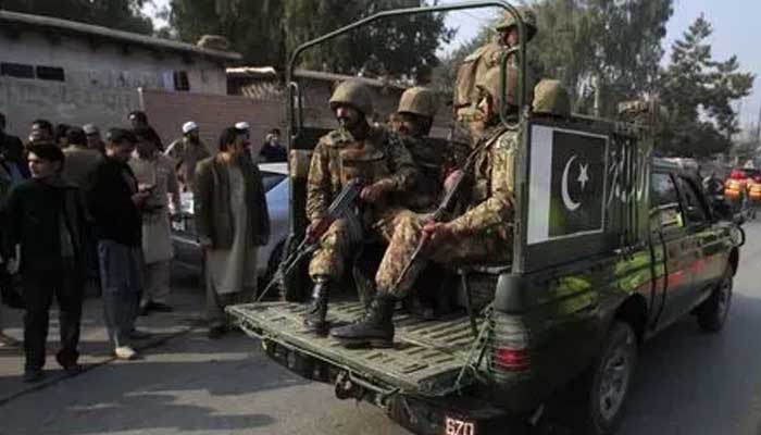 Security forces drive on a road leading to the Army Public School in Peshawar, December 16, 2014. — Reuters