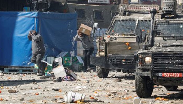 Palestinians take cover during clashes with Israeli forces amid a raid in Nablus in the Israeli-occupied West bank, February 22, 2023.— Reuters
