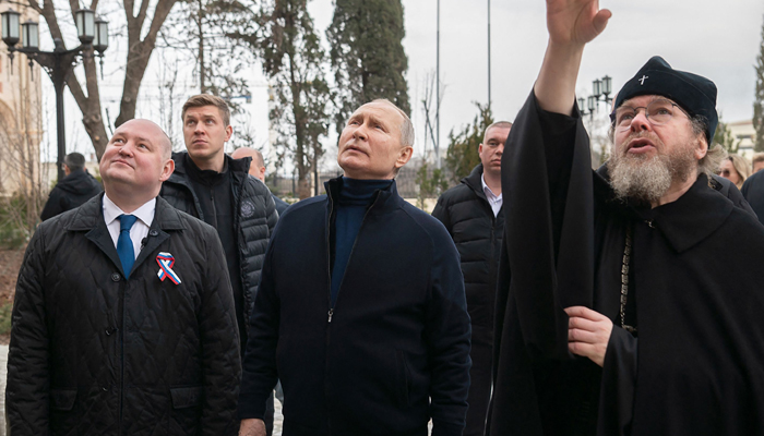Photograph shows Russian President Vladimir Putin (centre), Sevastopol Governor Mikhail Razvozhayev (left), listening to Metropolitan Tikhon Shevkunov (R) as he visits Chersonesos Taurica historical and archaeological park on 9th anniversary of the referendum on state status of Crimea and Sevastopol, on March 18, 2023. — AFP