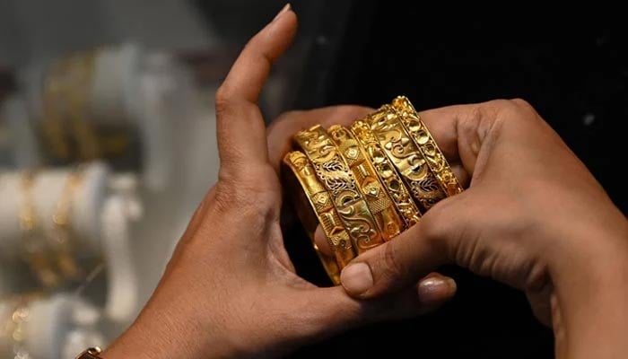 An undated image of a girl holding gold bangles. — AFP/File