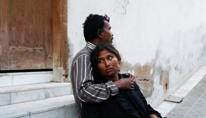 People mourn the death of a relative, who was killed with others in a stampede during handout distribution, at a hospital morgue in Karachi on March 31, 2023. — Reuters