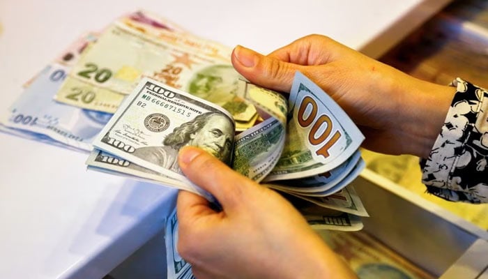 A money changer counts US dollar banknotes at a currency exchange office in Ankara, Turkey September 27, 2021. — Reuters