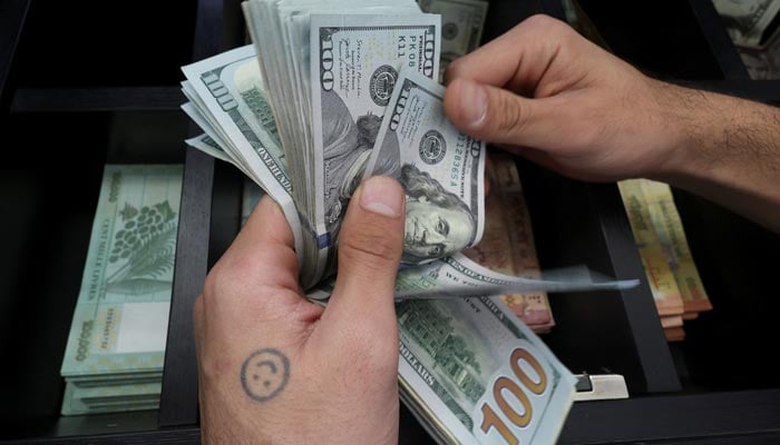 A money exchange vendor counts US dollar banknotes at a shop in Beirut, Lebanon March 10, 2023. — Reuters