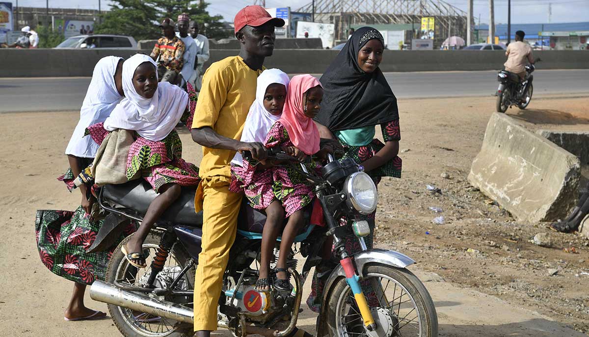 A family arrives for Eid ul Fitr prayer on a taxi bike at Kara Isheri, Ogun State in southwest Nigeria, on April 21, 2023.