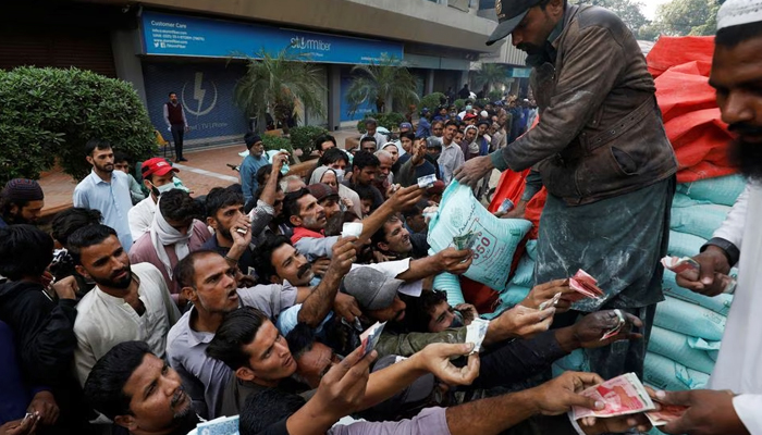 Men reach out to buy subsidised flour sacks from a truck in Karachi, on January 10, 2023. — Reuters