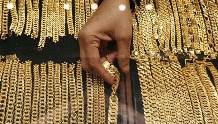 A vendor arranges gold chains displayed at a jewellery store in Kuala Lumpur, Malaysia on August 10, 2020. — Reuters/File