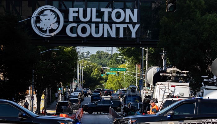 Police officers and media members surround the Lewis R. Slaton Courthouse ahead of an expected indictment of former US President Donald Trump in Atlanta, Georgia on August 14, 2023. — AFP